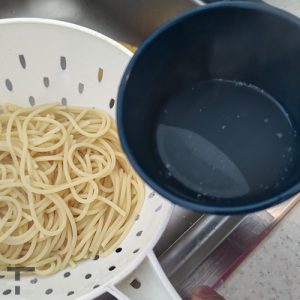 Strain pasta and reserve some water